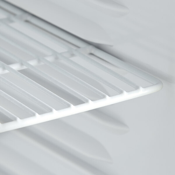 The white shelf inside an Avantco countertop display refrigerator.