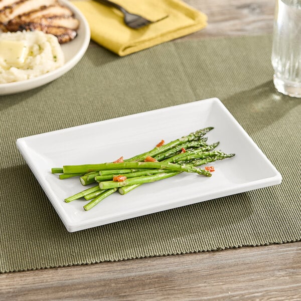 An American Metalcraft rectangular white mini melamine plate with asparagus and mashed potatoes on it.