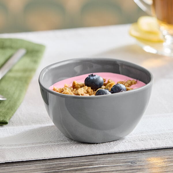 An American Metalcraft storm melamine bouillon cup filled with yogurt and blueberries on a table.