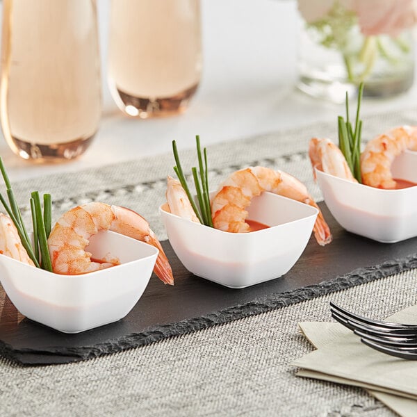 A black tray with small white plastic bowls filled with shrimp and green onions.