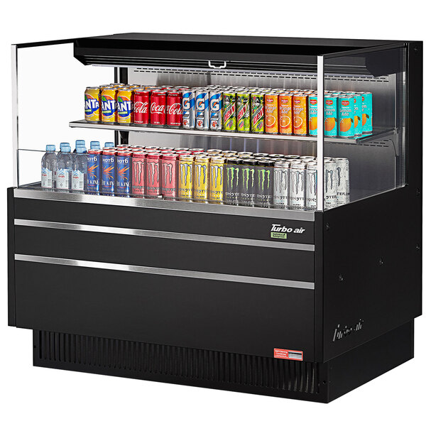 A black Turbo Air refrigerated curtain merchandiser with cans of soda on a shelf.