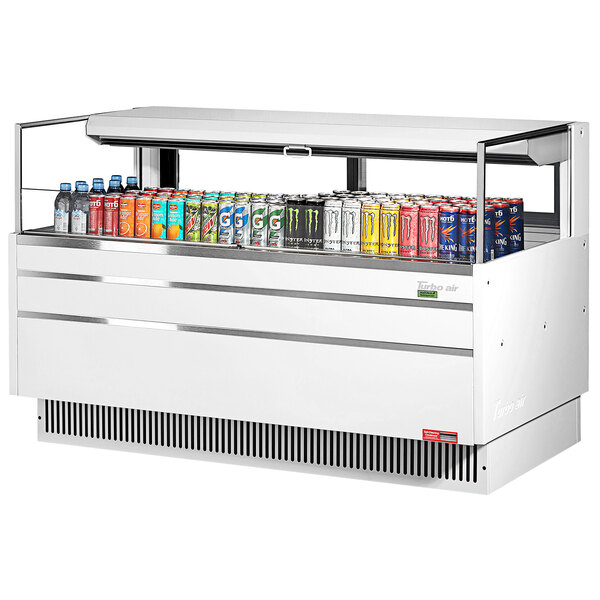 A white Turbo Air horizontal refrigerated open curtain merchandiser filled with cans of soda and energy drinks.