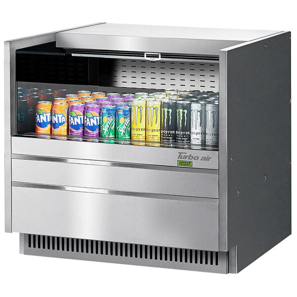 A Turbo Air drop-in refrigerated display case with cans of soda on shelves.