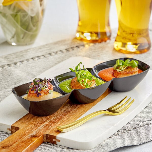 A Choice black plastic mini tray with three bowls of food and utensils on a table.