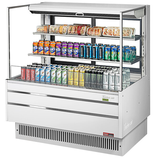 A white Turbo Air horizontal refrigerated open curtain merchandiser with drinks and cans.