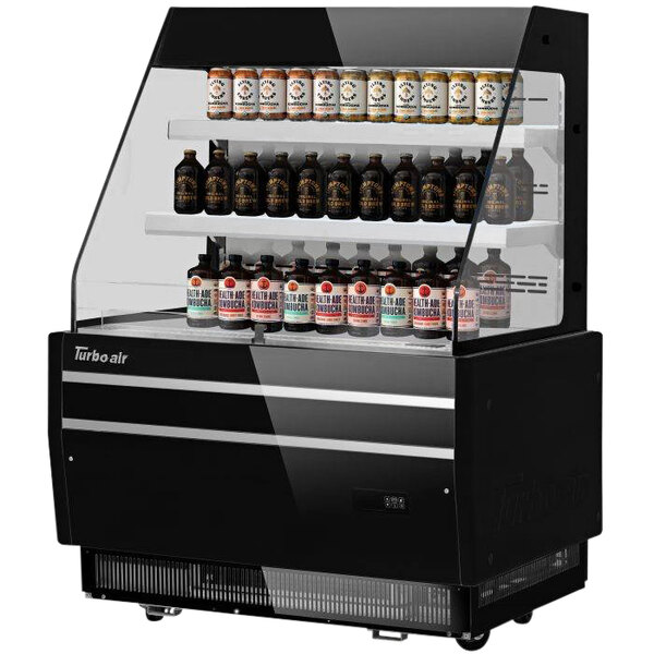 A black Turbo Air horizontal refrigerated display case with bottles on shelves.