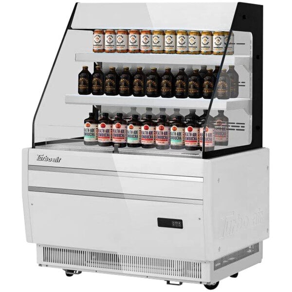 A white Turbo Air horizontal refrigerated display case with bottles on shelves.