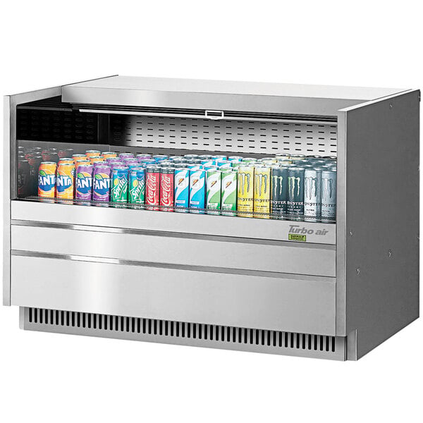 A Turbo Air stainless steel drop-in refrigerated display case with cans of soda.