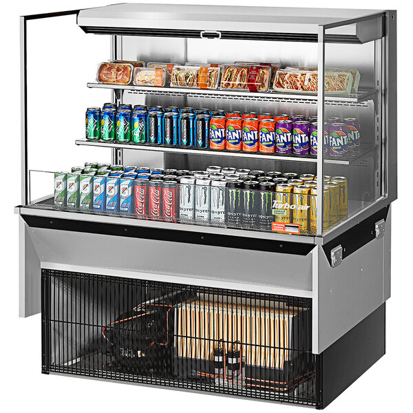 A Turbo Air stainless steel drop-in refrigerated open display case with drinks and snacks inside.