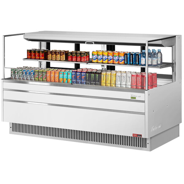 A white Turbo Air horizontal open curtain refrigerator with drinks and snacks on shelves.