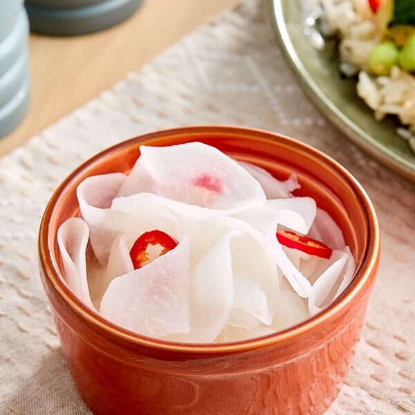 A plate of rice with sliced fresh daikon radish served as a vegetable side dish.