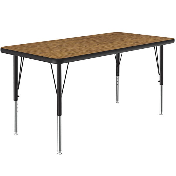 A rectangular table with a medium oak top and black legs.