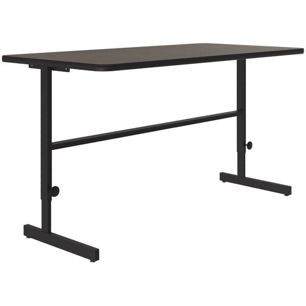 A black rectangular Correll standing height work station with a walnut thermal-fused laminate top and a black metal frame.