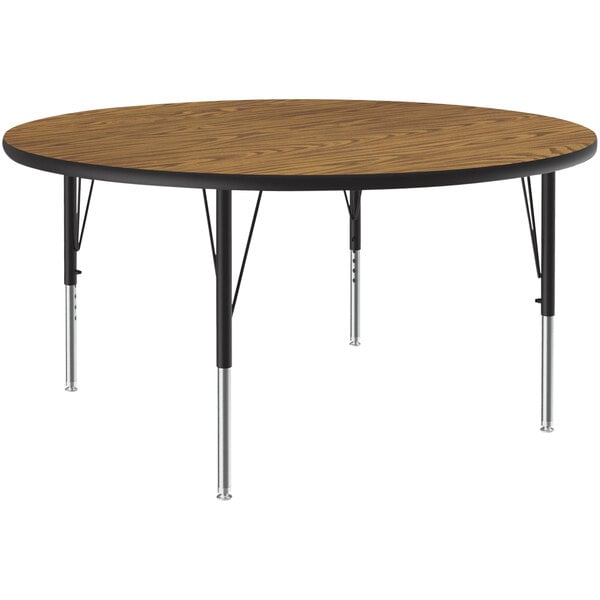 A Correll round activity table with a medium oak top and black metal legs.