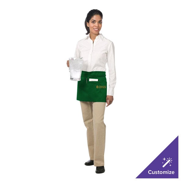 A woman wearing a green Chef Revival waist apron with three pockets holding a clear container.