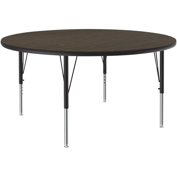 A Correll round activity table with black metal legs and a walnut brown top.