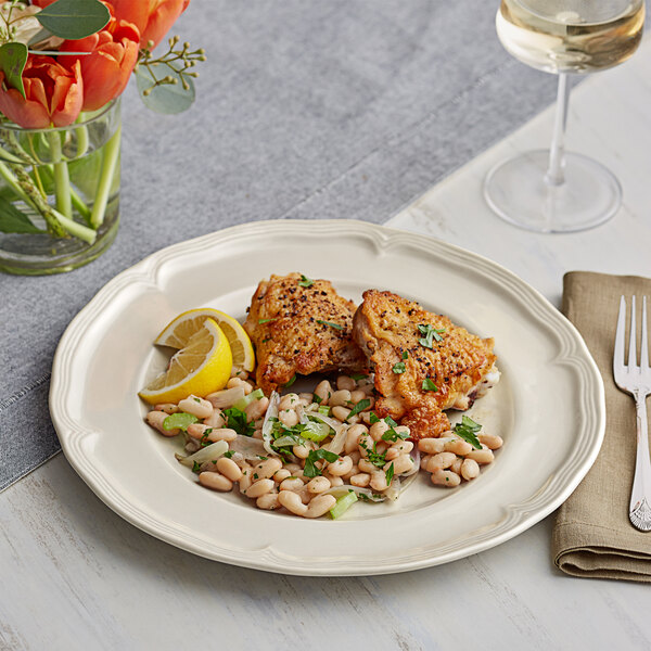 An Acopa Condesa porcelain plate with food and a glass of wine on a white background.