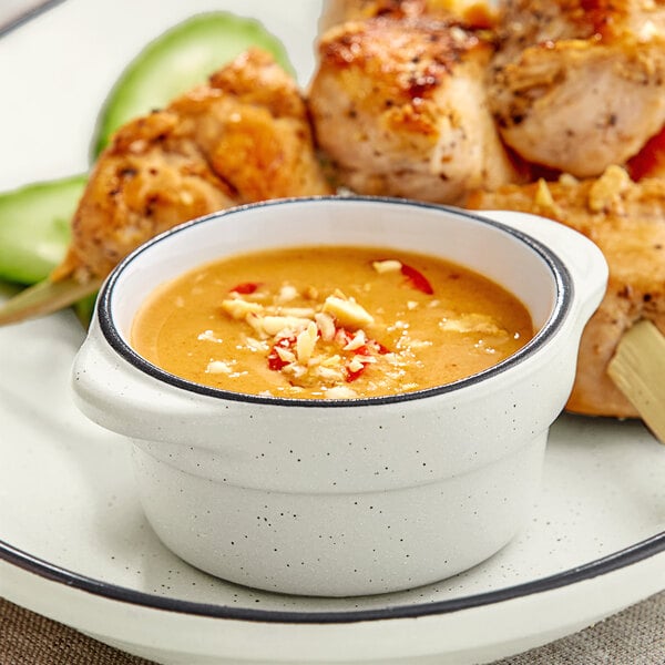 A plate of food with Acopa Embers grey stoneware sauce cups filled with sauce.