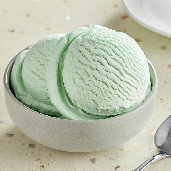 A white bowl of green Key Lime ice cream with a spoon.