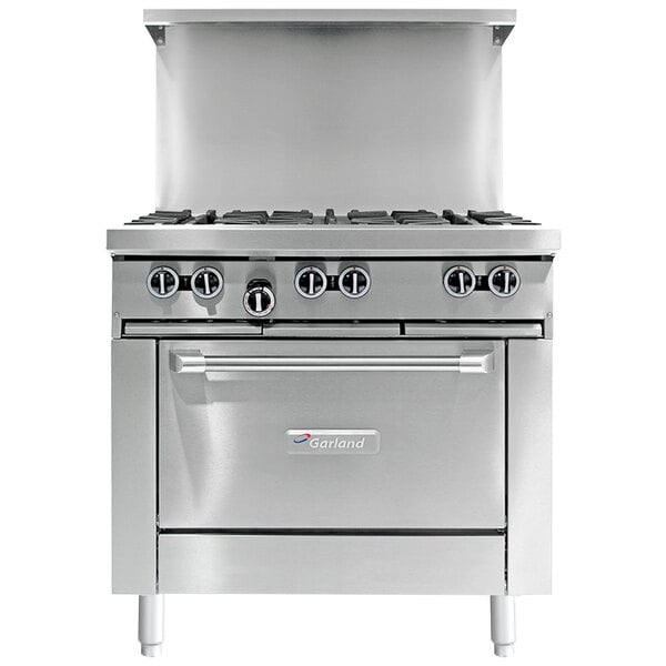 A stainless steel Garland commercial gas range with a griddle, burners, and storage.