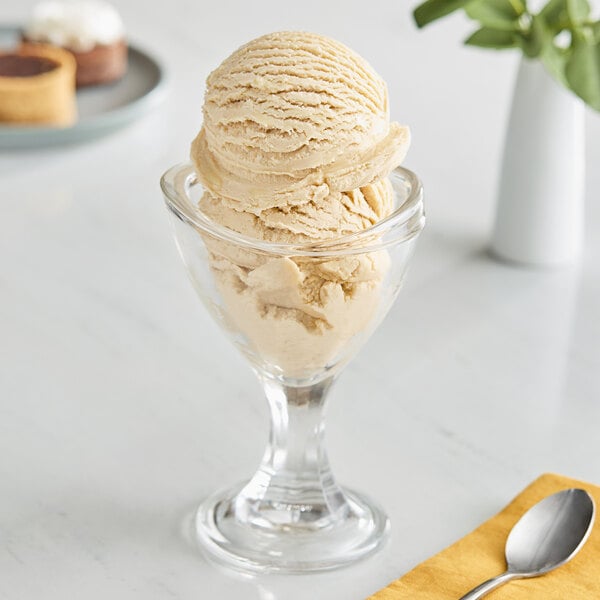 A glass with a scoop of Oringer Dulce de Leche ice cream in it.