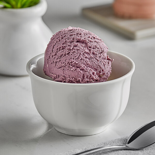 A bowl of ice cream topped with blueberries.