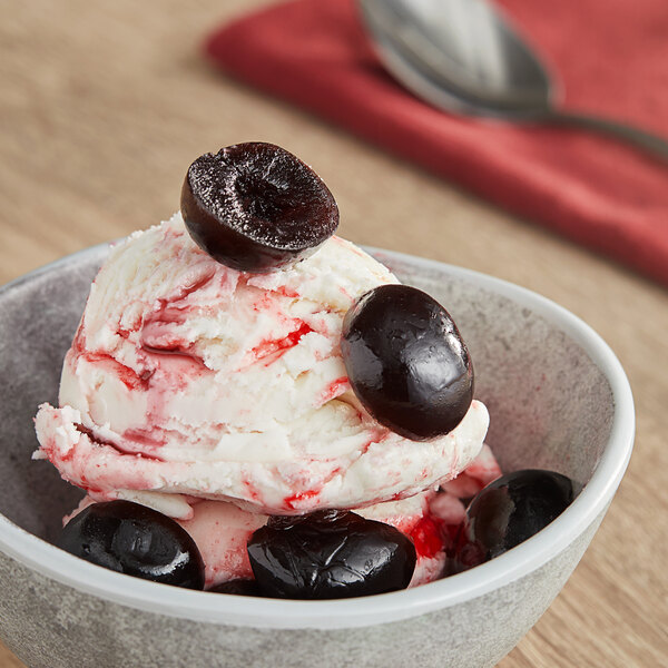 A bowl of ice cream with Oringer Black Cherry Halves in a bowl.