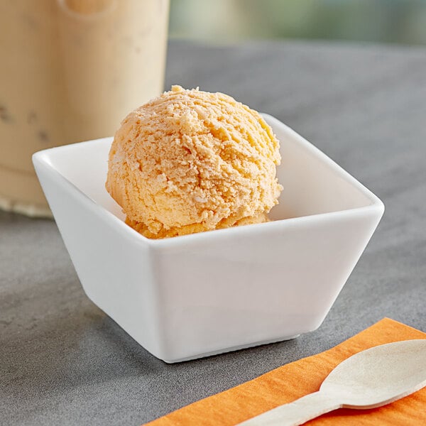 A white bowl with a scoop of Oringer Orange Pineapple Puree ice cream.