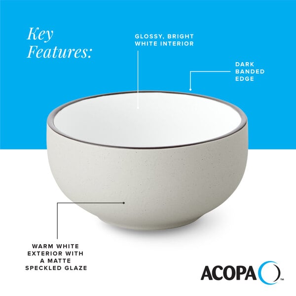 A gray matte stoneware bowl with a glossy white interior, dark banded edge, and speckled glaze.