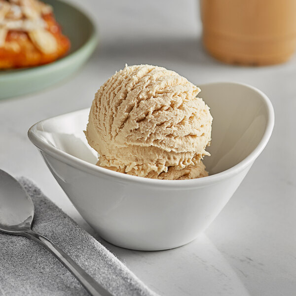 A scoop of Oringer cookie dough ice cream in a white bowl with a spoon.