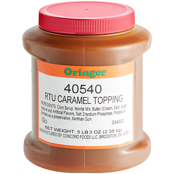 A jar of Oringer caramel dessert topping on a school kitchen counter.