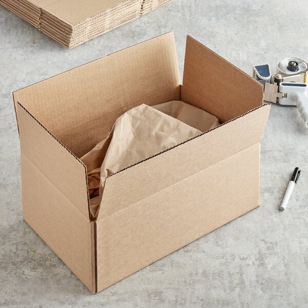 A cardboard box with a brown bag inside.