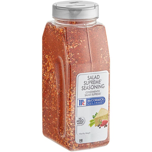 A plastic container of McCormick Culinary Salad Supreme seasoning with red seasoning inside.