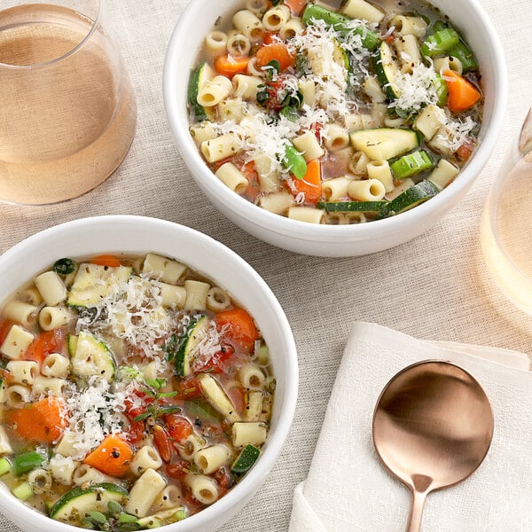 Two bowls of soup with noodles and vegetables seasoned with McCormick Culinary Italian Seasoning.