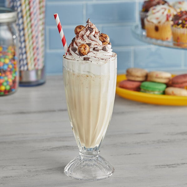 A glass of Oringer Malt Milkshake with whipped cream and a straw.