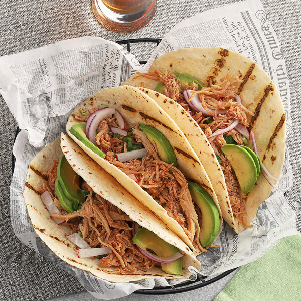 A group of tacos on a plate with meat and avocado seasoned with McCormick Culinary Rotisserie Chicken Seasoning.