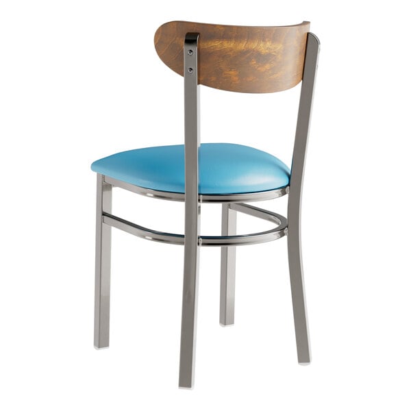 A Lancaster Table & Seating Boomerang chair with a blue vinyl seat and vintage wood back.