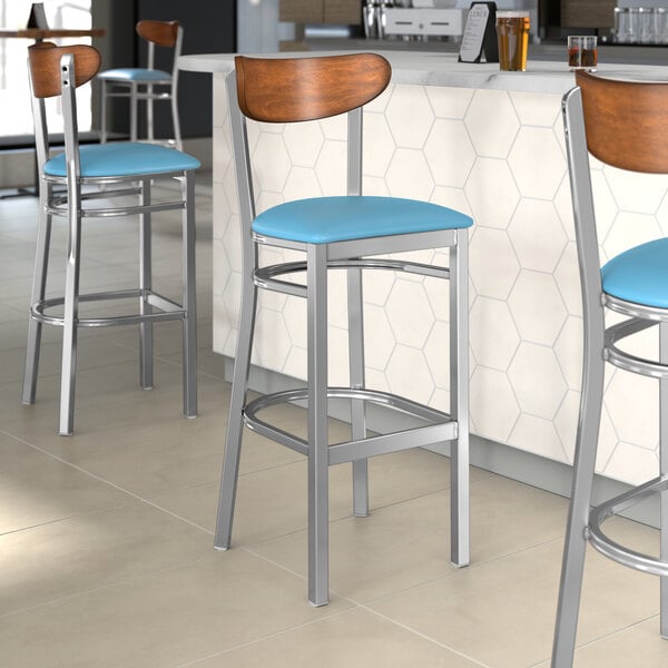 Lancaster Table & Seating bar stools with blue vinyl seats and antique walnut backs.