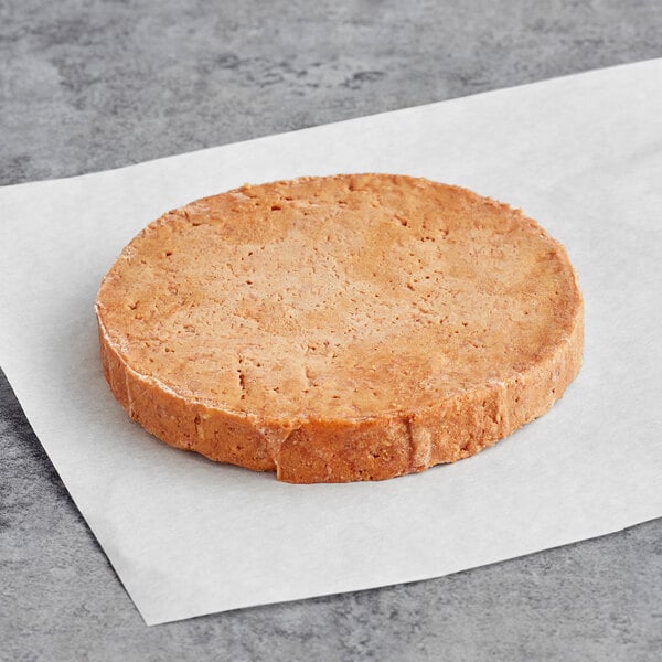 A Before the Butcher plant-based vegan burger patty on a white surface.