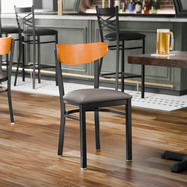 A black metal chair with a dark gray vinyl seat and a cherry wood backrest.