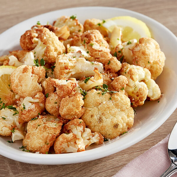 A white plate with a cauliflower head on it.