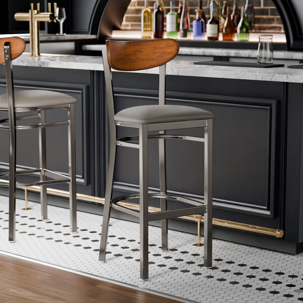 Two Lancaster Table & Seating Boomerang bar stools with a counter.
