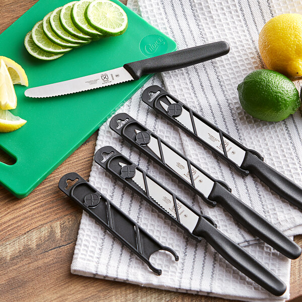 A group of Mercer Culinary bar knives with slide-on guards on a white towel.