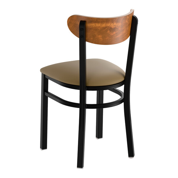 A black metal chair with a taupe vinyl seat and a curved vintage wood backrest.