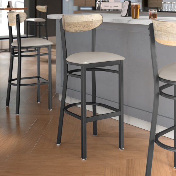 Lancaster Table & Seating Boomerang Series bar stools with driftwood backs and light gray seats.