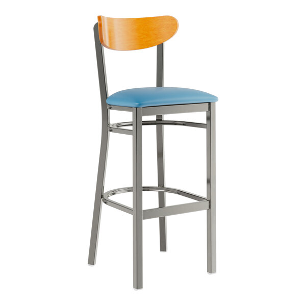 A Lancaster Table & Seating Boomerang bar stool with a blue vinyl seat and cherry wood back and a metal frame.