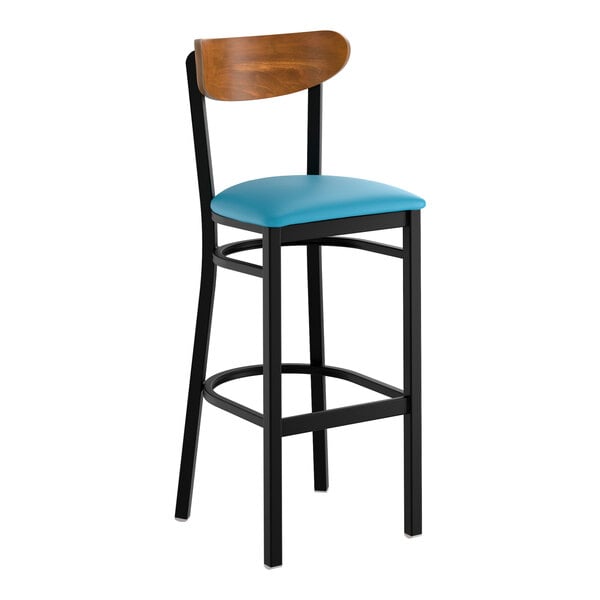 A bar stool with a black metal frame, blue vinyl seat, and a curved wooden backrest.