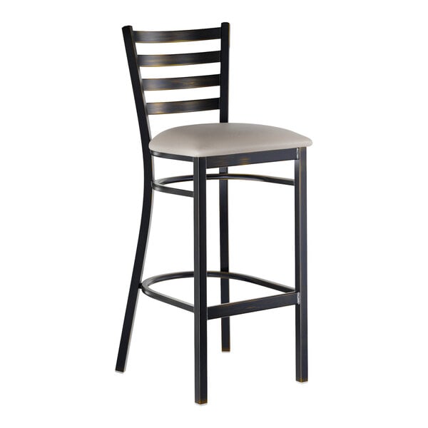 A metal ladder back bar stool with a distressed copper finish and a light gray vinyl padded seat.