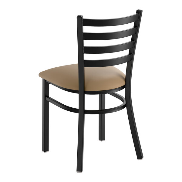 A black metal ladder back chair with a taupe vinyl padded seat.