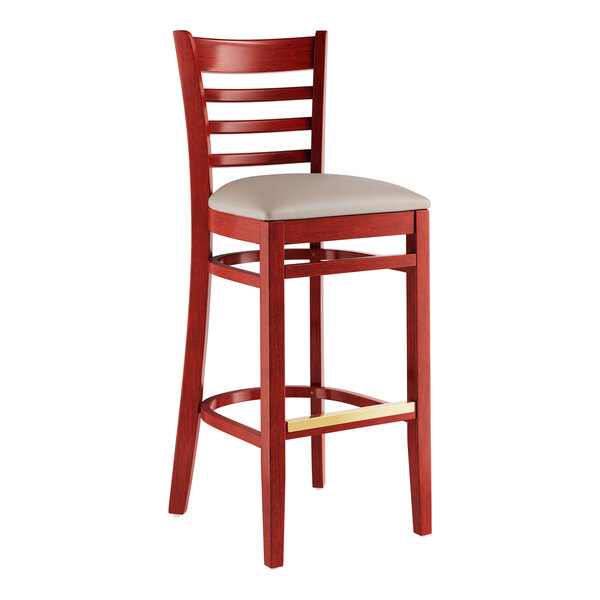 A mahogany wood Lancaster Table & Seating ladder back bar stool with a light gray vinyl seat